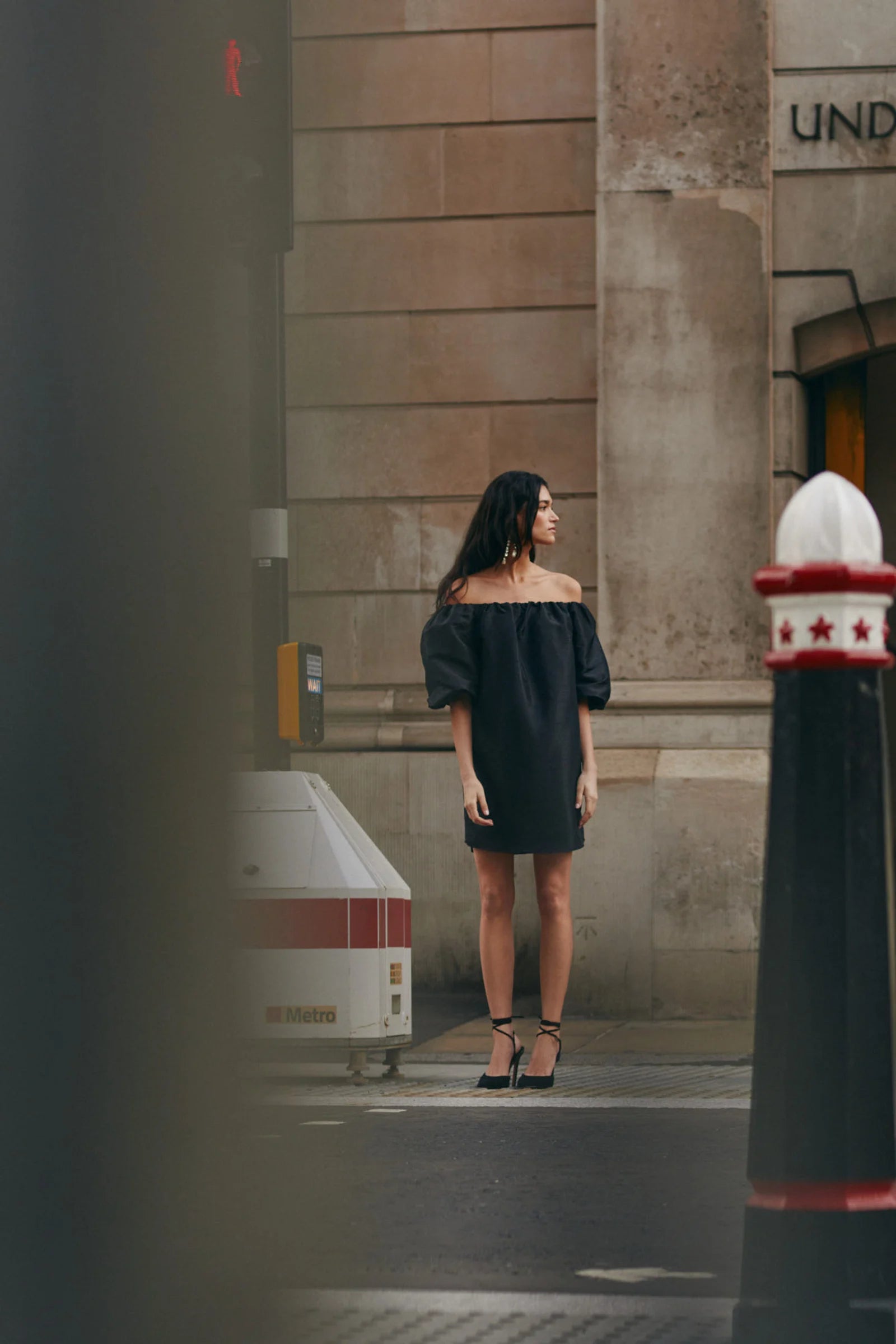 On location 2 Malina Off-shoulder black mini dress with short pouf sleeve and wide fit. The perfect addition to your luxury designer resort wear wardrobe.