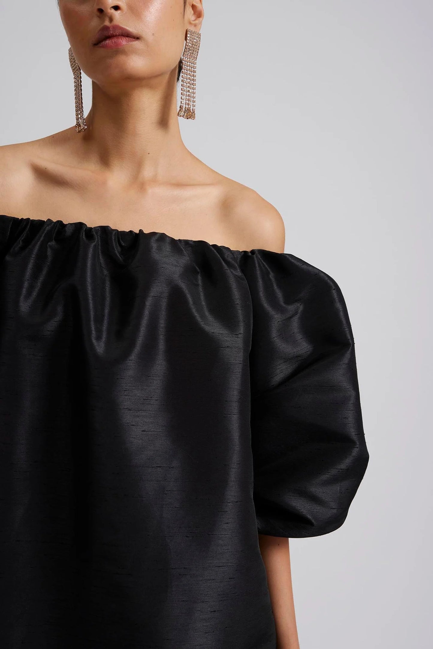 Close up 1 Malina Off-shoulder black mini dress with short pouf sleeve and wide fit. The perfect addition to your luxury designer resort wear wardrobe.