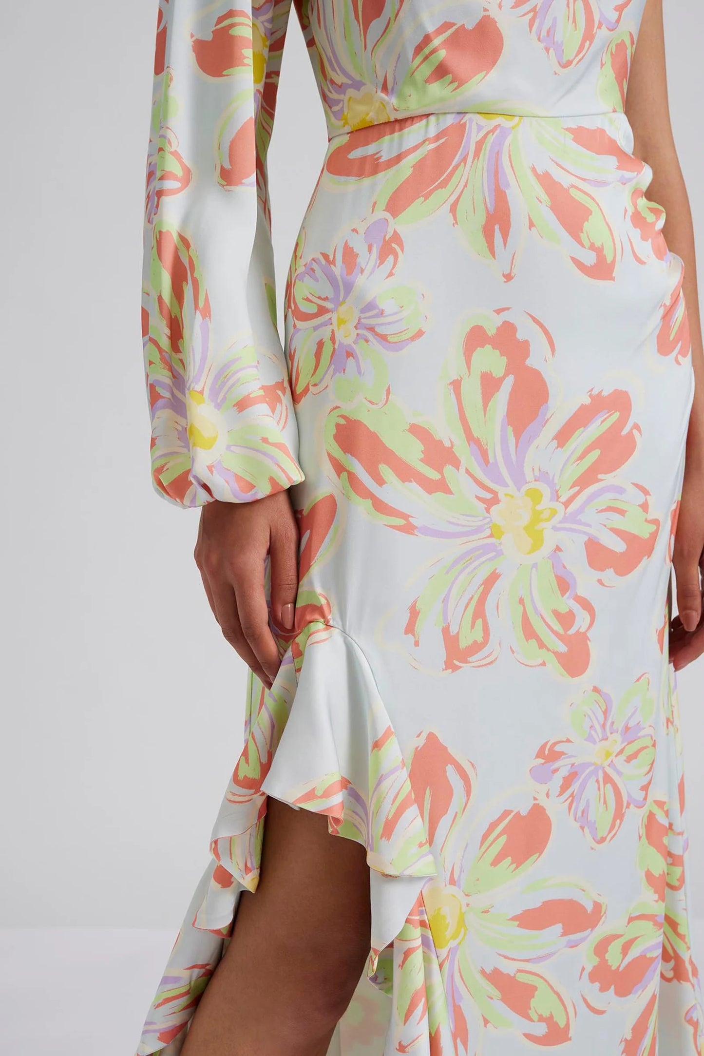 Close up Malina Printed one shoulder long sleeved maxi dress with ruffle details and slit in the side. Effortlessly elegant and stylish, the Joslin One Shoulder Maxi Dress in Blue Lily is a must-have for any formal occasion. This one-shoulder design features flowy maxi skirt, creating a timeless and sophisticated look. Made with high-quality materials, this dress is both comfortable and chic. The perfection addition to your luxury designer resort wear wardrobe.