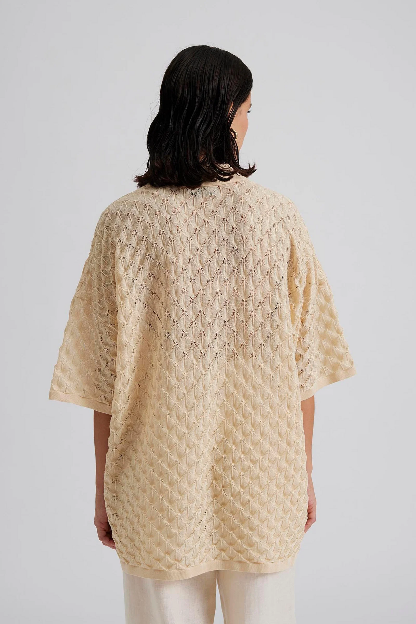 Back facing Malina Short sleeve crocheted shirt with buttons in the front. The perfect addition to your luxury designer resort wear wardrobe.