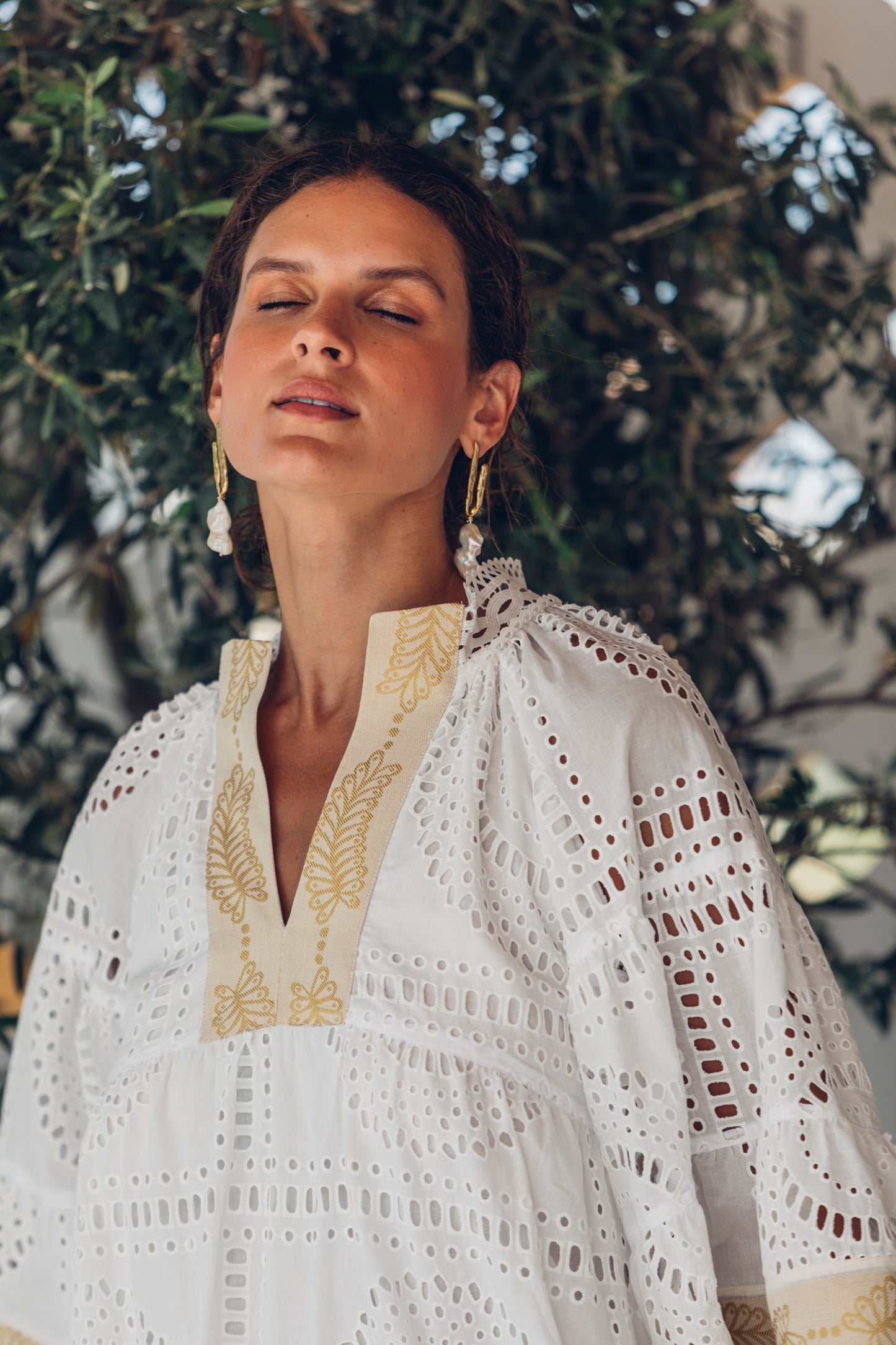 Close up **PRE-ORDER 1st APRIL** Nema Elle Broderie White Cut Out Mini Dress with gold detail. The perfection addition to your luxury designer resort wear wardrobe.