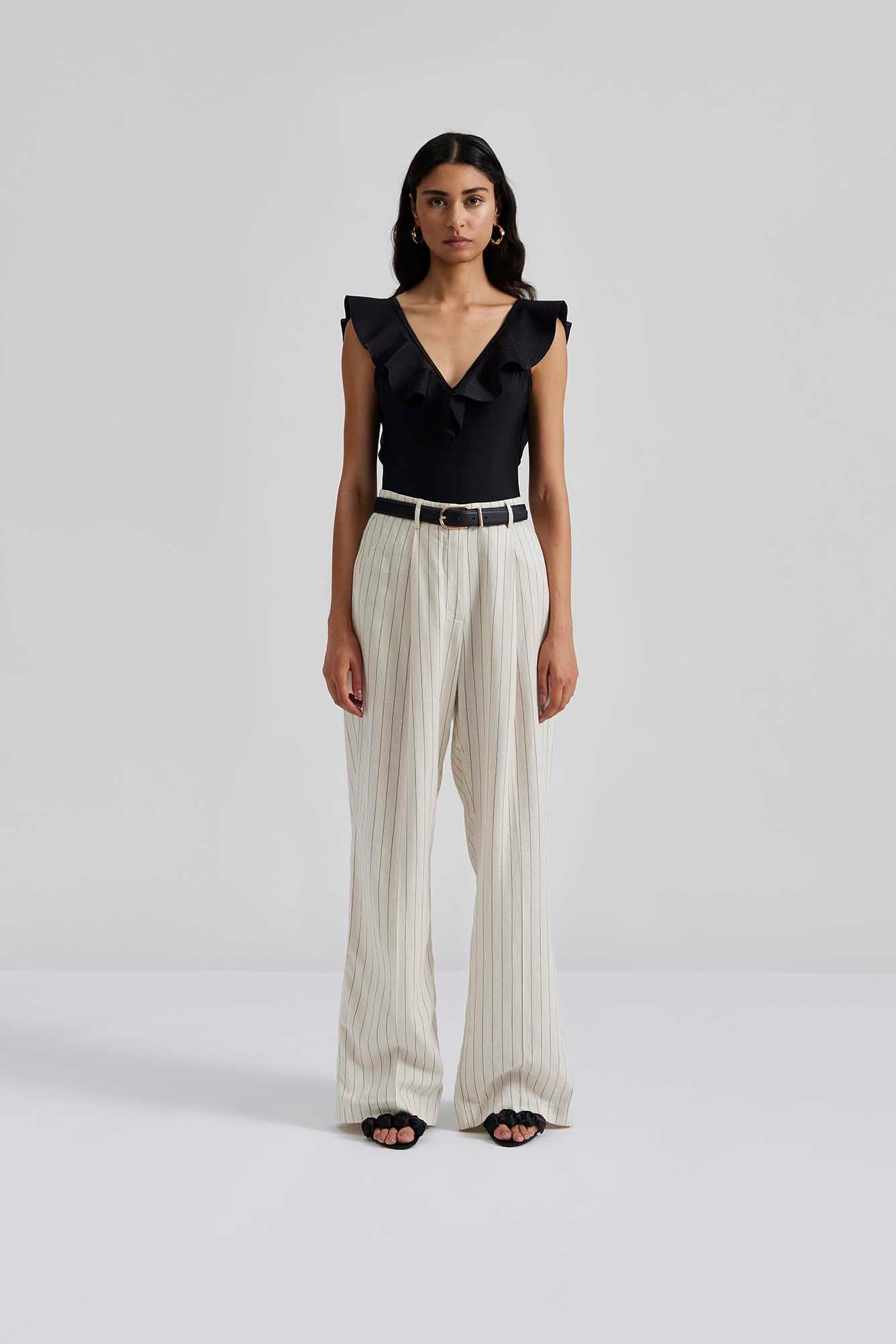 with trousers Malina Swimsuit with v-neck and ruffle detail. The perfect addition to your luxury designer resort wear wardrobe.