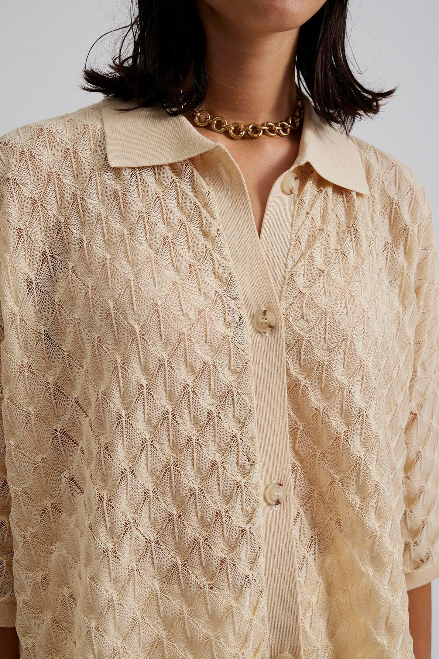Close up 2 Malina Short sleeve crocheted shirt with buttons in the front. The perfect addition to your luxury designer resort wear wardrobe.