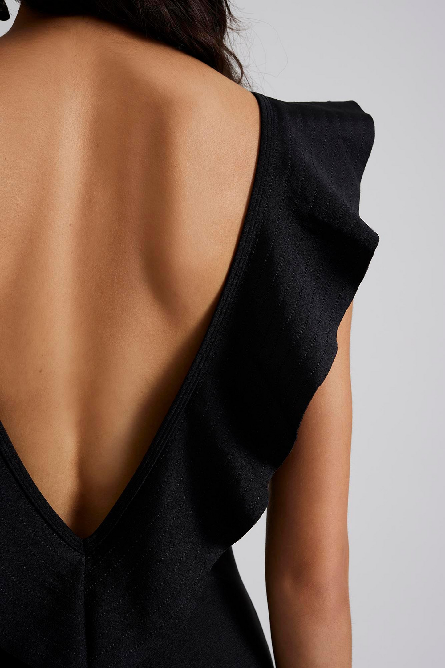 close upMalina Swimsuit with v-neck and ruffle detail. The perfect addition to your luxury designer resort wear wardrobe.