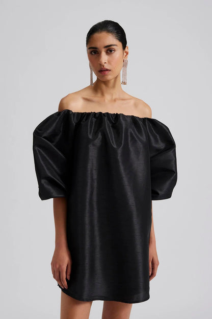 Front facing 2 Malina Off-shoulder black mini dress with short pouf sleeve and wide fit. The perfect addition to your luxury designer resort wear wardrobe.  